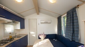 A compact kitchen with a dining area, a built-in stove, and a window with curtains.