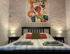 A hotel room with a bed, two bedside tables, and a poster on the wall. - Beautiful Restored Farmhouse with Private Pool in Malaga, Andalucia (Malaga,Casabermeja)