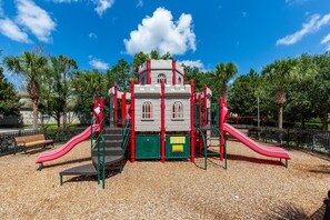 A playground with two slides, a climbing structure, and a bench. - Pawnall Bliss | 4BR Cozy Home w/ Private Pool, Game Room, and Themed Kids' Room Near Disney (Kissimmee)
