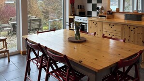 Una cocina moderna con una isla grande, sillas de madera y vistas al exterior.