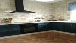 A kitchen with dark blue cabinets, a black range hood, and a tiled backsplash. - HOUSE WITH PRIVATE PLOT - CONIL DE LA FRONTERA (FREE WIFI) (Conil de la Frontera)