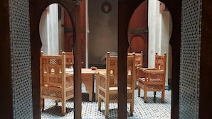 Un intérieur doté d’un sol carrelé, de meubles en bois et d’arcades.