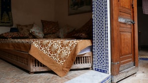 Une chambre traditionnelle avec un lit, une armoire en bois et un papier peint à motifs.