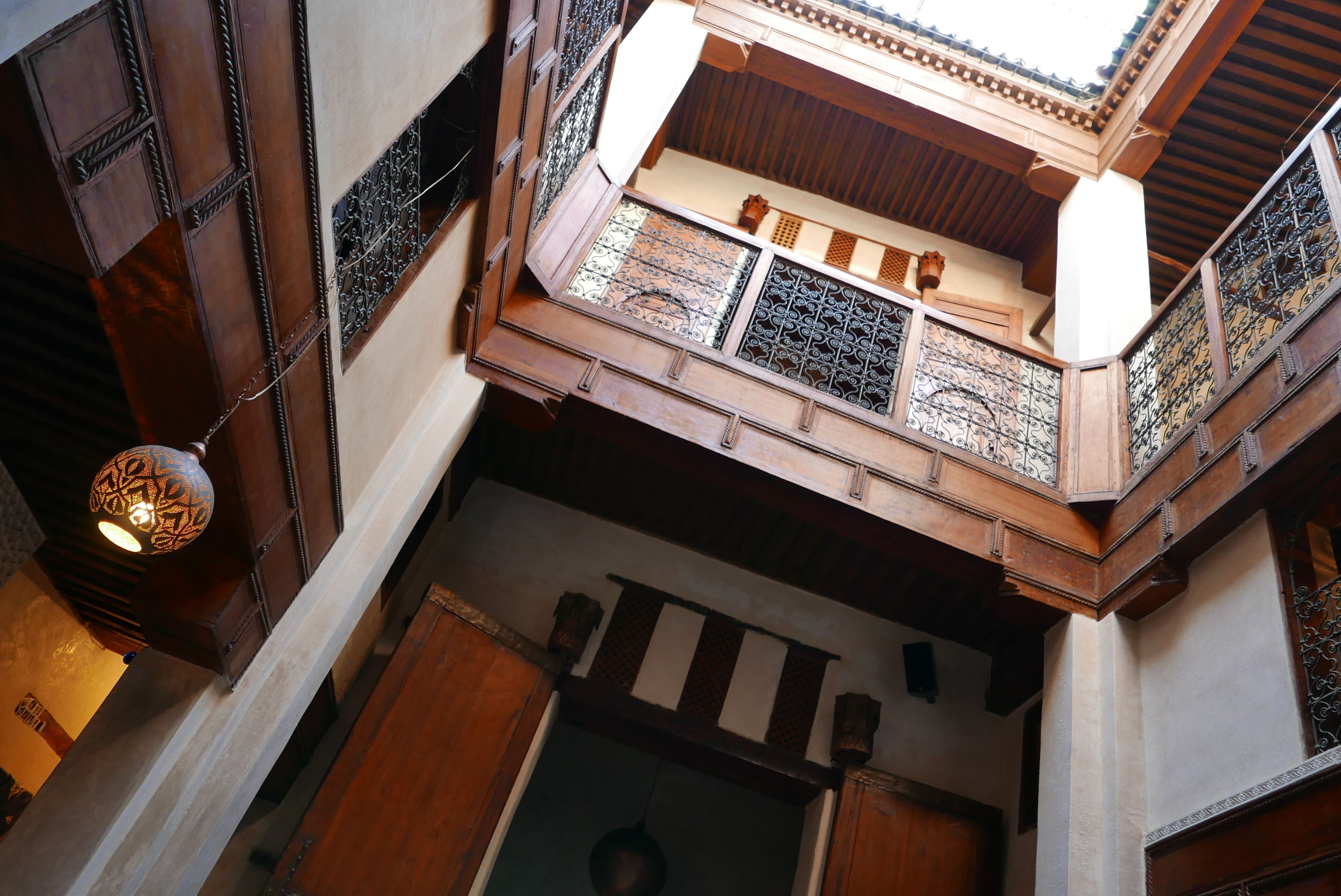 A high-ceilinged room with wooden beams and intricate metal railings.