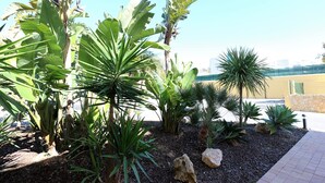 A landscaped garden with various tropical plants and rocks. - Beautiful new two bedroom apartment in Albufeira, Algarve<br> (Albufeira)
