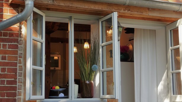 A window with a view of a room, a brick wall, and a wooden beam. - stylish and nostalgic near Timmendorfer Strand Baltic Sea and old town Lübeck (Offendorf)