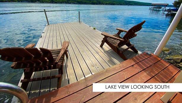 Terraza de madera con sillas Adirondack con vista a un lago y orientación al sur.