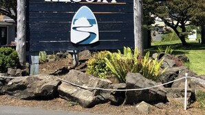 A sign for Neskwin Resort with a logo featuring a wave and a boat. - Prime Ocean/Beach Location & Spectacular View!Ground Level Condo,Fresh Update (Neskowin)