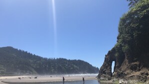 A beach with clear skies, rocky cliffs, and a calm sea. - Prime Ocean/Beach Location & Spectacular View!Ground Level Condo,Fresh Update (Neskowin)