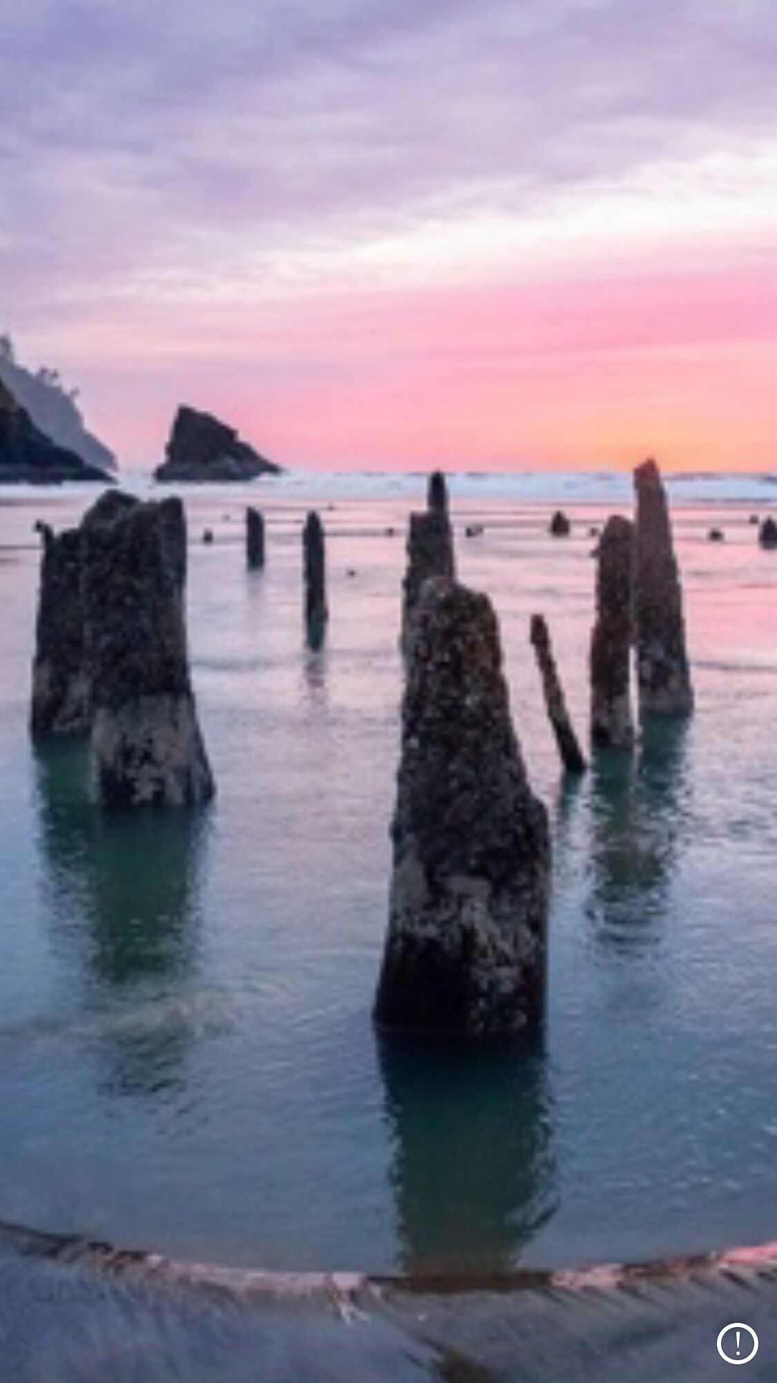 A coastal scene with rock formations emerging from the water, likely a natural feature.