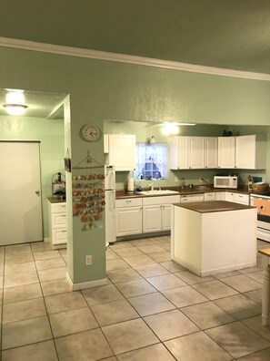 Kitchen features a central island, window, and various appliances.