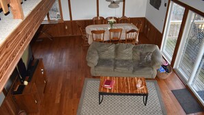 Un salón acogedor con sofá, mesa de centro y zona de comedor con sillas y mesa.