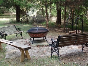 A park with a fire pit, benches, and a picnic table. - WoodHaven, A Wooded Get Away Where Memories Are Made That Comfortably Sleeps 8 (Nashville)