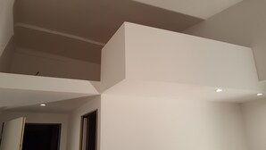 Ein modernes Interieur mit hoher Decke und eingelassener Beleuchtung.