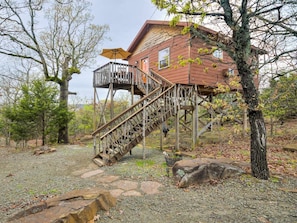 Une maison en bois avec un escalier en bois menant à une terrasse.