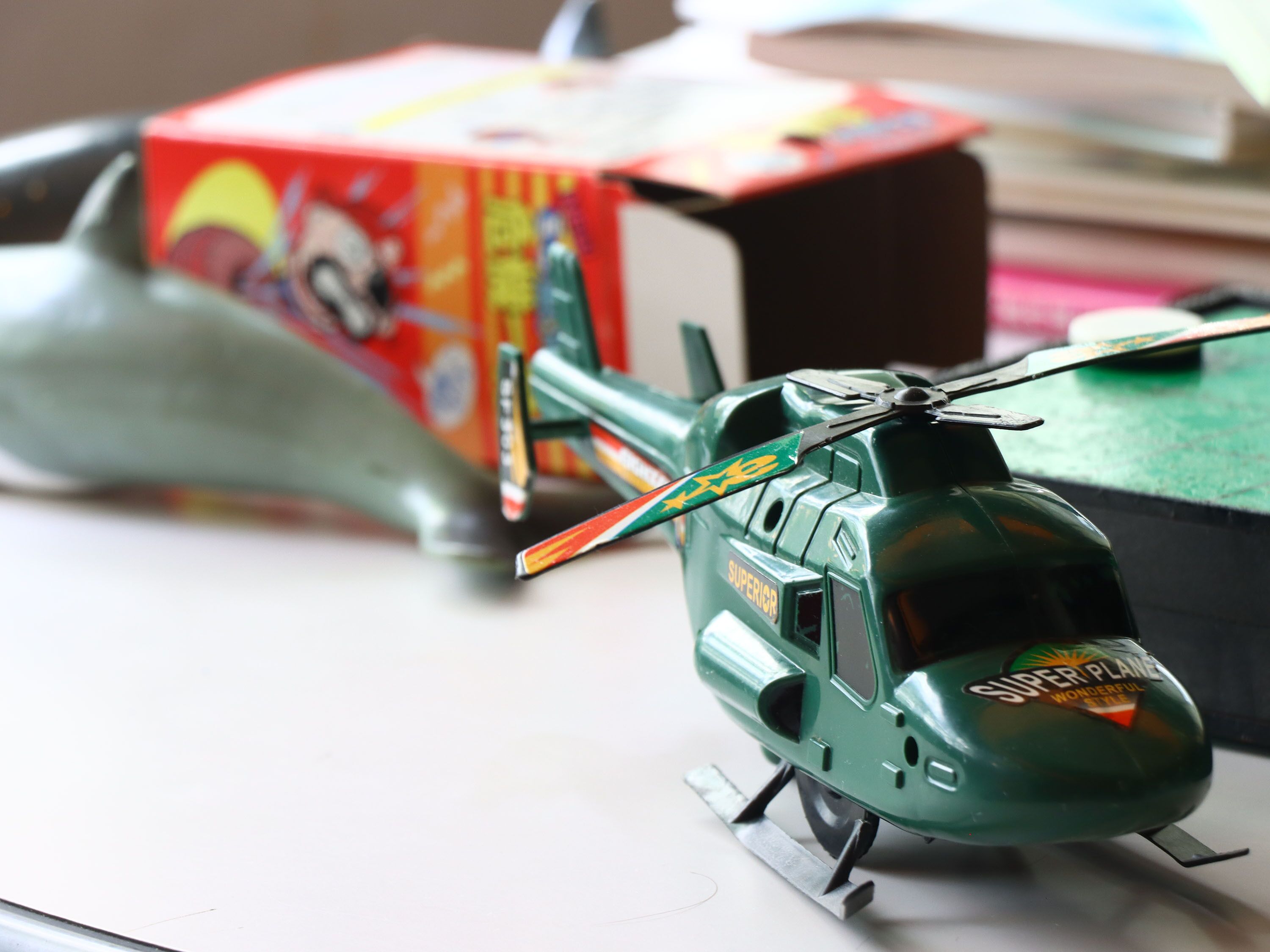 A toy helicopter and a toy submarine on a table.