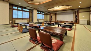 Une pièce de style japonais traditionnel, avec un sol recouvert de tatamis, de petites tables basses et des coussins.