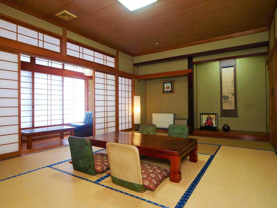 A traditional Japanese room with tatami flooring, a low wooden table, and shoji screens.