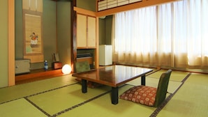 Une pièce de style japonais traditionnel, avec un sol recouvert de tatamis, une table basse et des portes coulissantes.