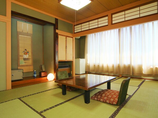 A traditional Japanese room with tatami flooring, a low table, and sliding doors.