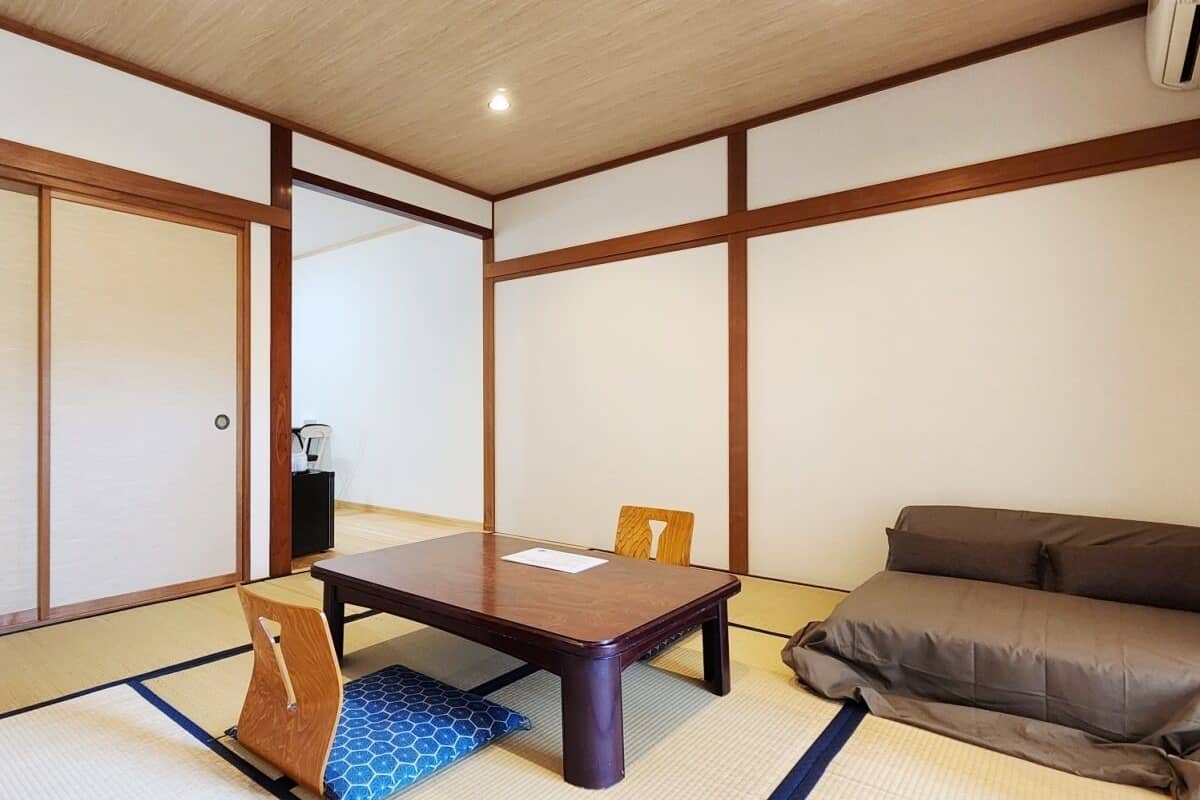 Ett traditionellt japanskt rum med tatamimattor på golvet, ett lågt bord och en soffa.
