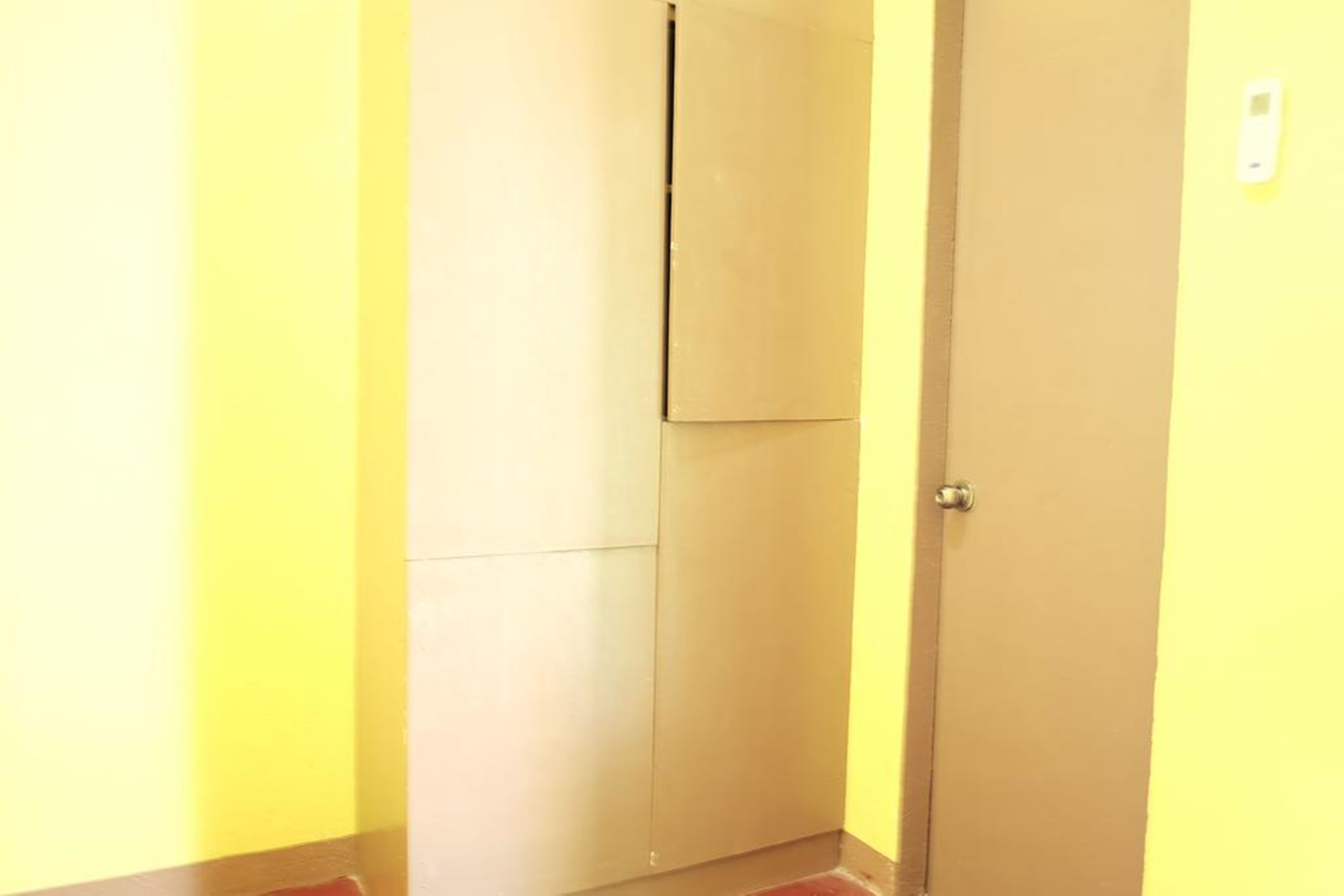 Una puerta cerrada con picaporte y un interruptor de luz en la pared.