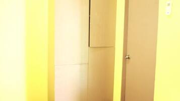 Una puerta cerrada con picaporte y un interruptor de luz en la pared.