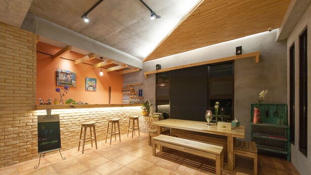 Un restaurante acogedor con pared de ladrillo, barra de madera y menú en una pizarra.