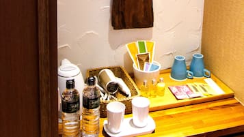 A breakfast setup with a coffee maker, bottles, cups, and a basket.