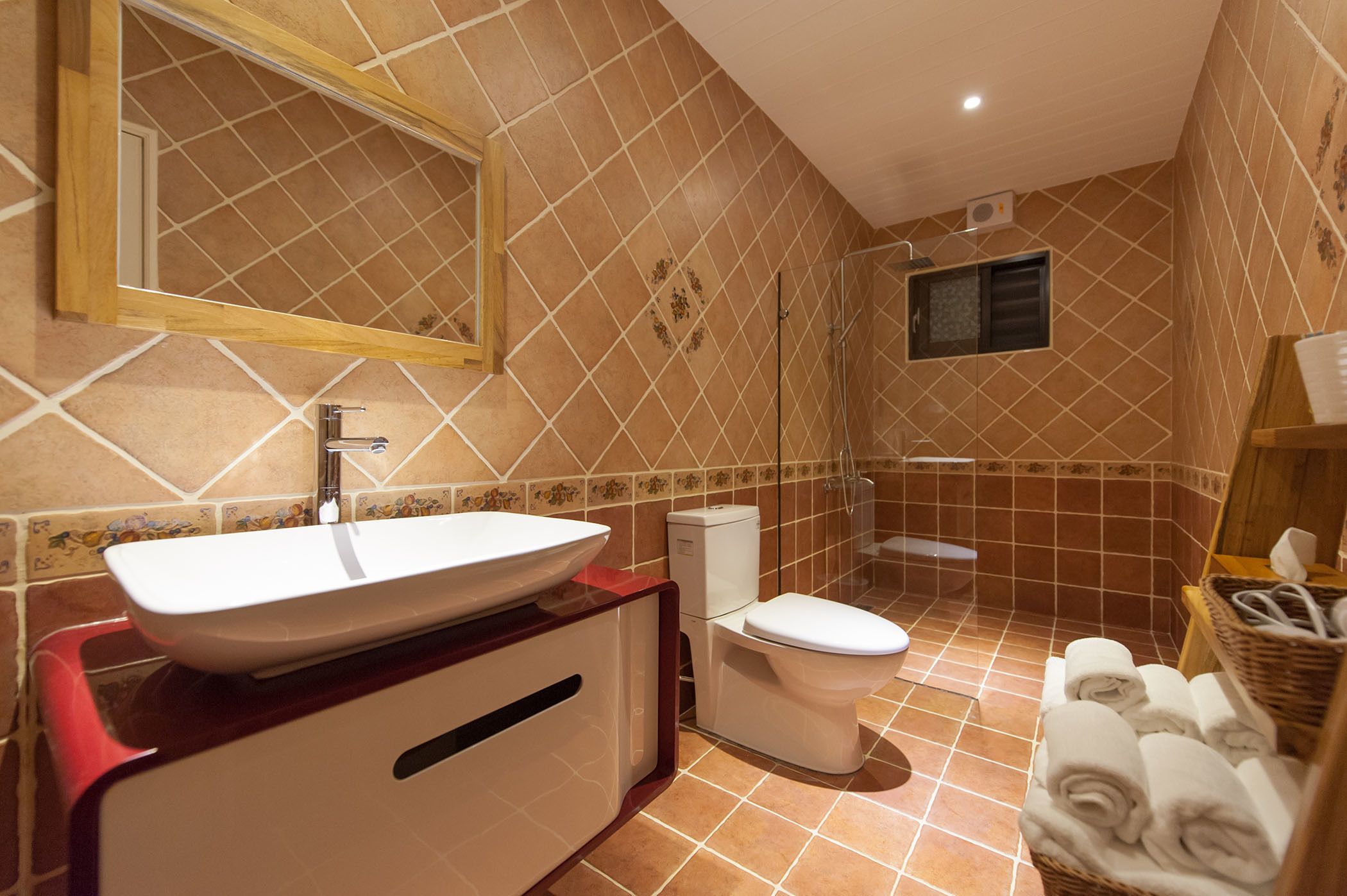 Un baño con un espejo grande, un lavamanos blanco, un inodoro y una zona de ducha.