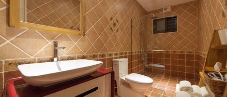 A bathroom with a large mirror, a white sink, a toilet, and a shower area.