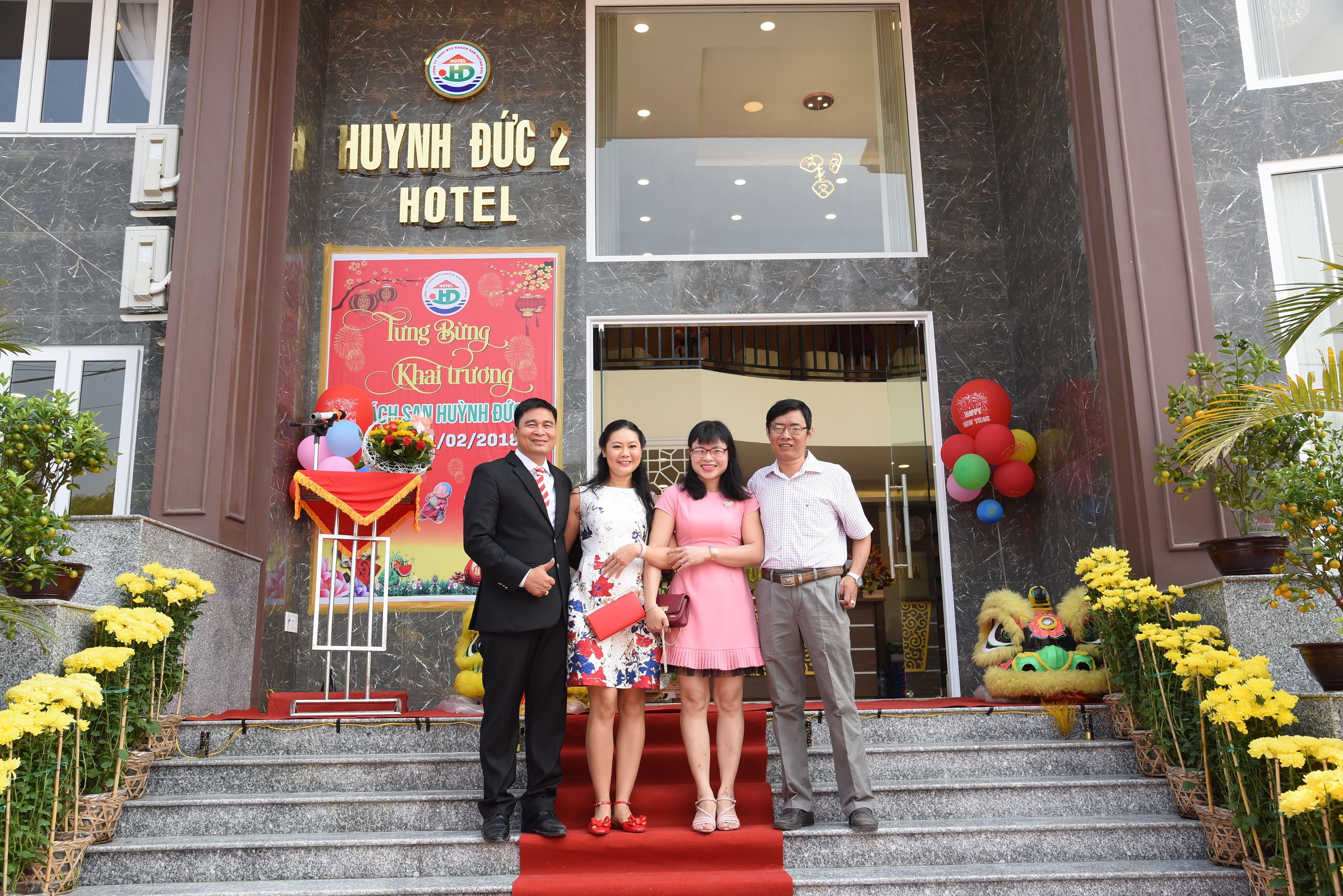 A hotel entrance with a red carpet, a signboard, and a lion dance performance.