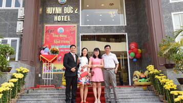 A hotel entrance with a red carpet, a signboard, and a lion dance performance.