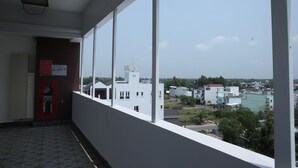 A balcony with a view of a town and a building with a sign that reads "HOTEL". - Huynh Duc 2 Hotel (Cao Lanh)