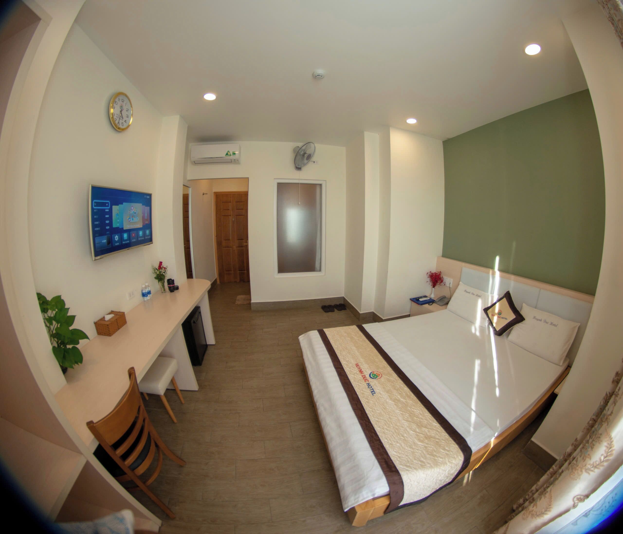 Een hotelkamer met een bed, bureau, stoel en televisie.