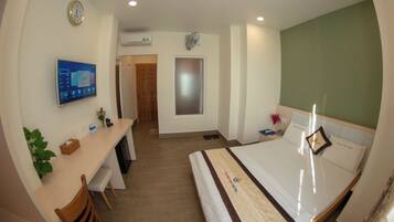 Een hotelkamer met een bed, bureau, stoel en televisie.