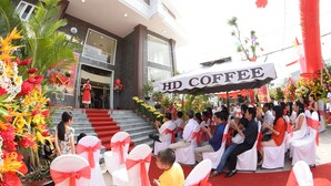 A formal event at a hotel with a stage, seated guests, and floral decorations. - Huynh Duc 2 Hotel (Cao Lanh)
