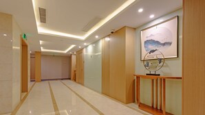A hotel hallway with a polished marble floor, wooden paneling, and a framed artwork on the wall. - Echarm Hotel Shanghai Hongqiao Airport (Shanghai)