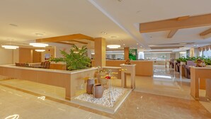 A modern hotel lobby with a reception desk, seating area, and decorative plants. - Echarm Hotel Shanghai Hongqiao Airport (Shanghai)