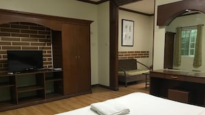 A hotel room with a bed, a TV, a wardrobe, a chair, and a mirror.