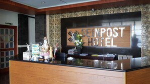 A reception desk with a wooden finish, a large sign reading "SEINPOST HOTEL", and a statue of a deity.