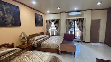 A hotel room with two beds, a bench, a lamp, and artwork on the walls.