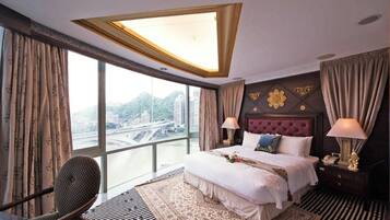 Habitación de hotel con una cama grande, vistas a la ciudad y un diseño de techo moderno.