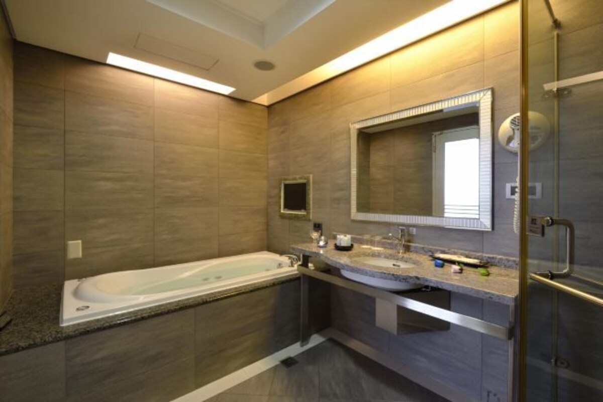 Un baño moderno con bañera, tocador con espejo y cabina de ducha de vidrio.