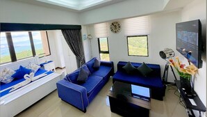 A modern living room with a sofa set, a flat-screen TV, and a chandelier. - Splendido Tower 2 Ann's Unit  (Laurel)