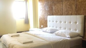 A neatly made bed with white linens and pillows, a marble headboard, and a window with curtains. - Panda House Chiang Mai (Chiang Mai)