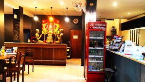 A restaurant with a counter, chairs, a refrigerator, and a Buddha statue. - Panda House Chiang Mai (Chiang Mai)