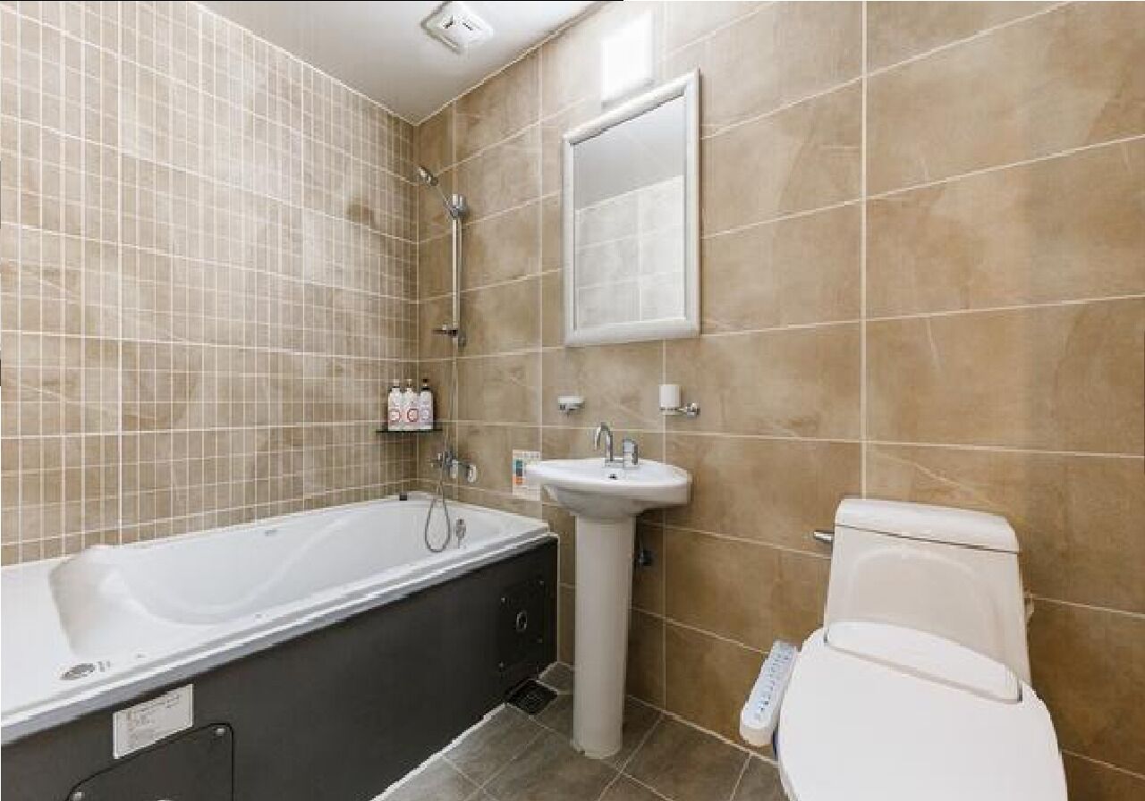 Een badkamer met een bad, wastafel en toilet.