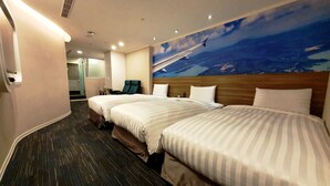A hotel room with two beds, a mural of a landscape, and a seating area with chairs. - Ximen Airline Hotel (Taipei)