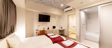 A hotel room with two beds, a desk, a TV, a bathroom with a shower and bathtub, and a ceiling with a textured pattern.